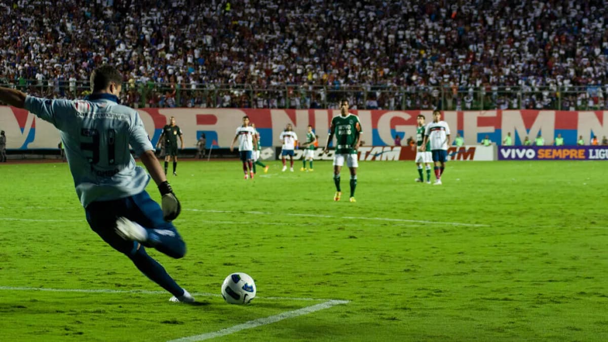 Jogador do Bahia em ação durante partida no estádio do Pituaçu, com torcida ao fundo