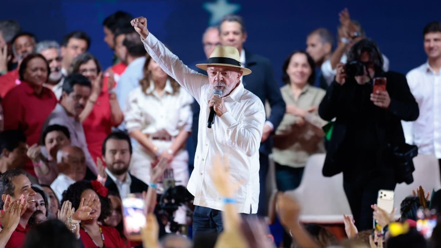 Lula discursa com o punho erguido durante a convenção do PT em São Paulo, cercado por apoiadores