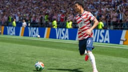 Malik Tillman, da seleção dos Estados Unidos, corre em campo com a bola durante partida com a camisa número 17
