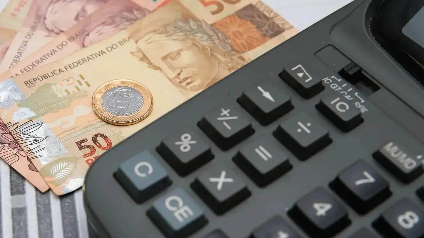 Notas de real e calculadora, representando o mercado financeiro brasileiro