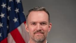 Retrato oficial de Jamieson Greer, representante comercial dos Estados Unidos, com a bandeira americana ao fundo