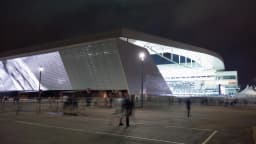 Vista externa iluminada da Neo Química Arena, do Corinthians, à noite