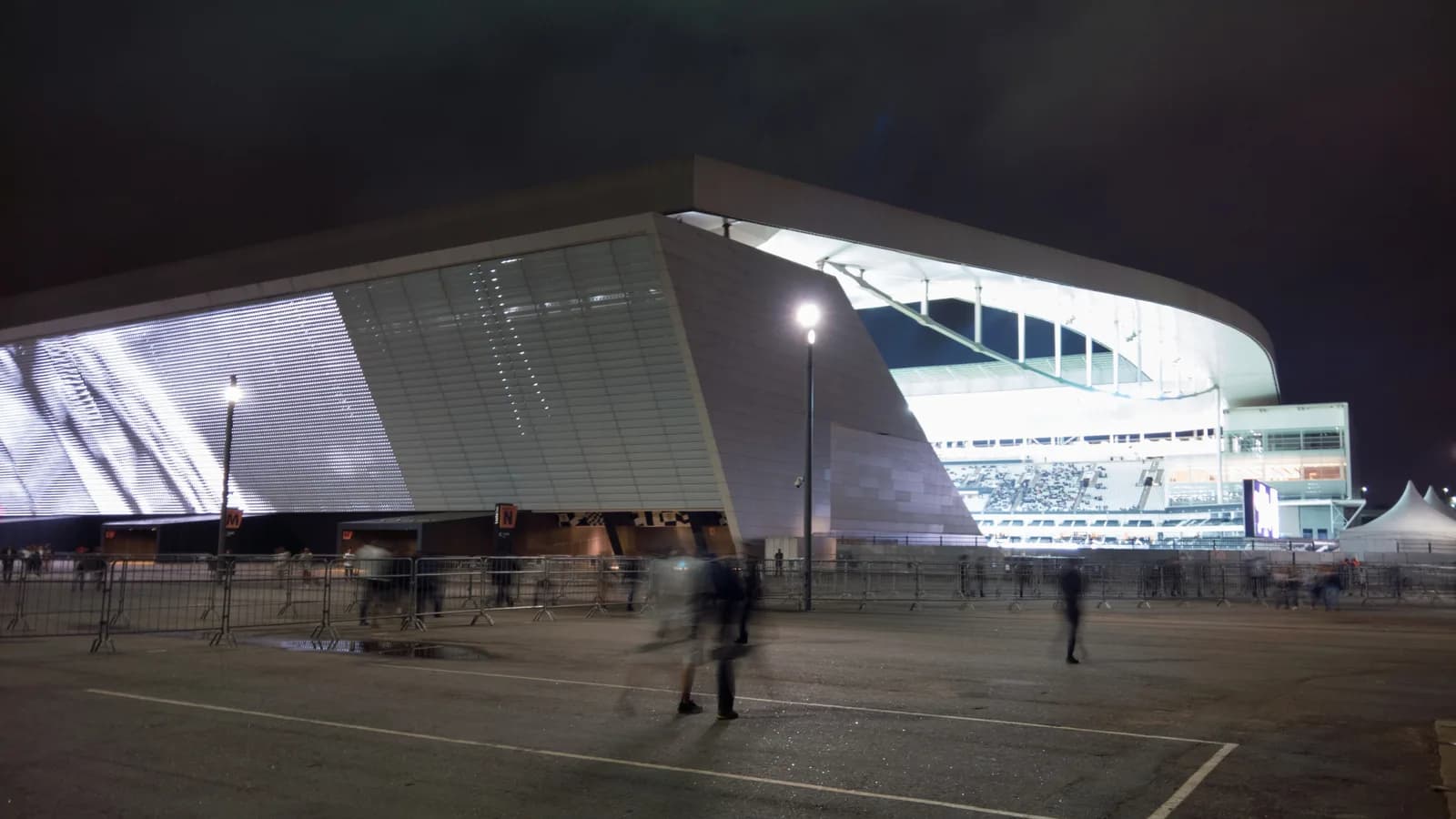Vista externa iluminada da Neo Química Arena, do Corinthians, à noite