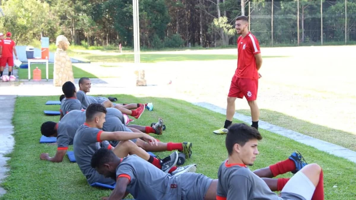 Atletas alongam no gramado após treino, sessão de recuperação pós-exercício