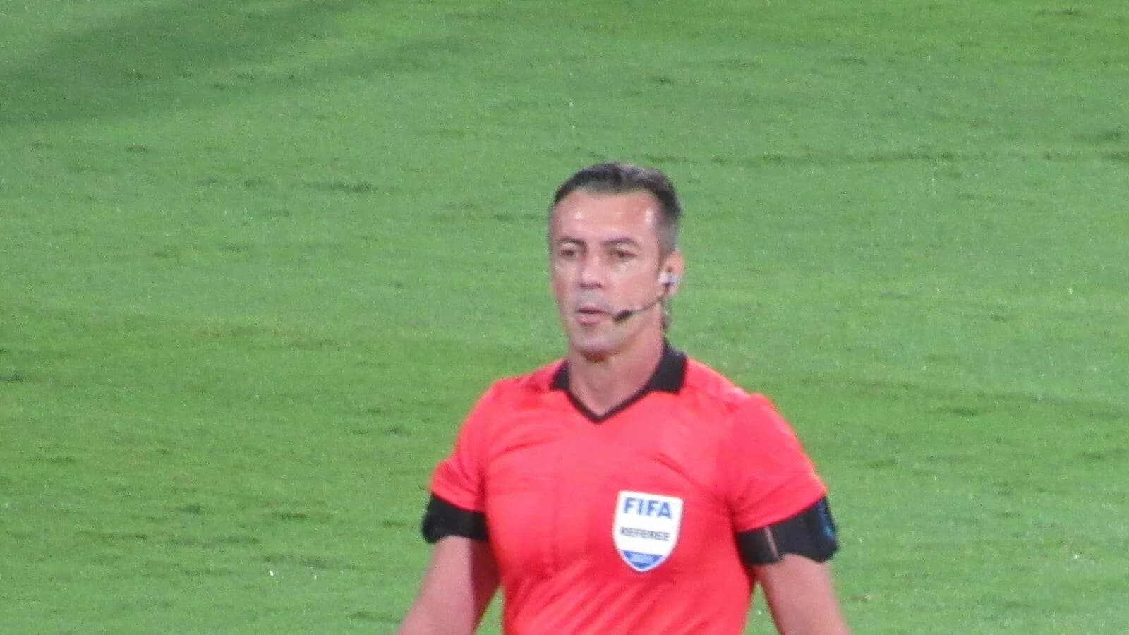 Árbitro de futebol com uniforme da FIFA em campo