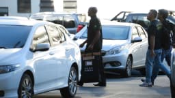 Agentes da Polícia Federal carregam material apreendido durante operação