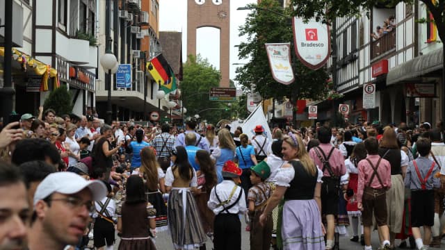 Multidão em festa tradicional de outubro com trajes típicos, em evento no Brasil