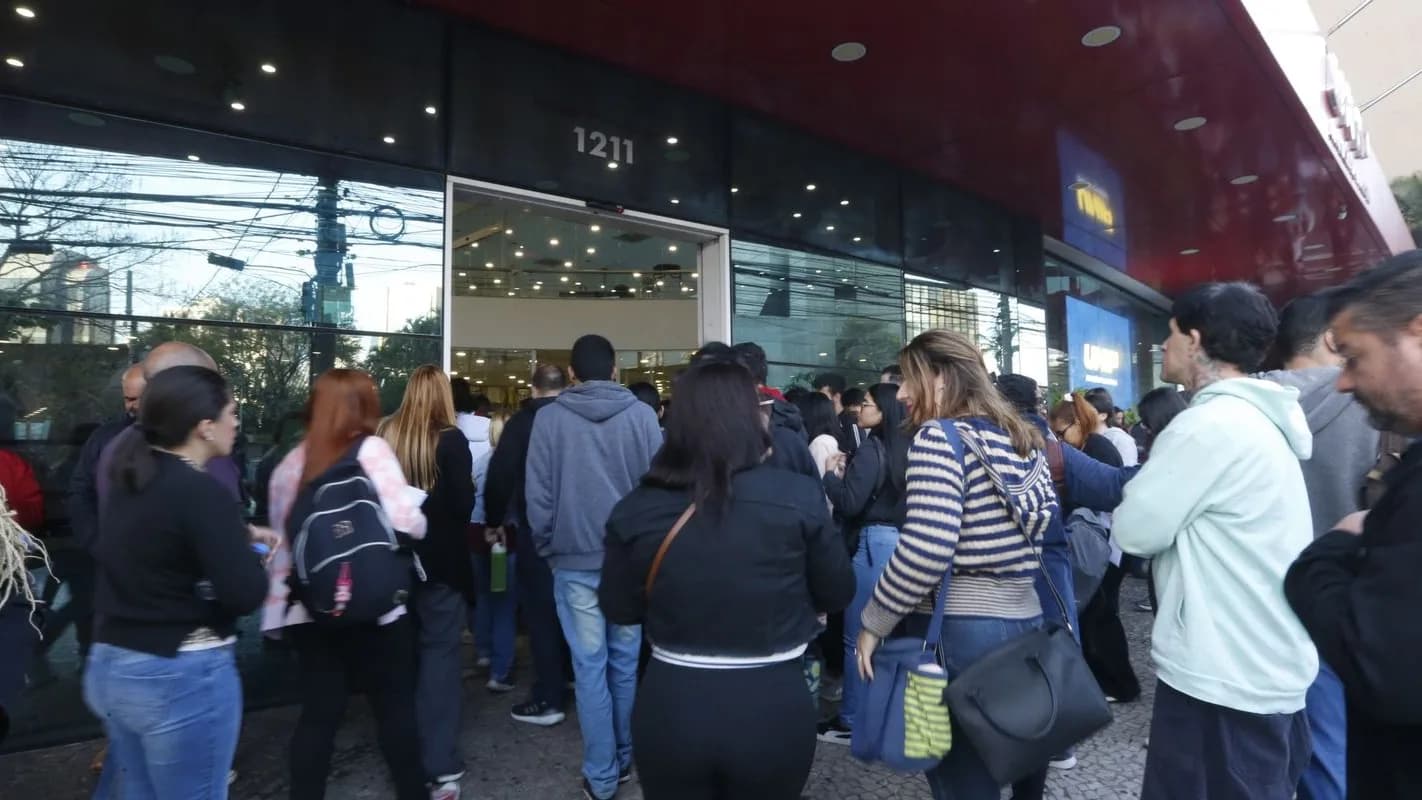 Candidatos aguardam em fila na entrada de um local de prova de concurso público