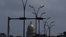 Postes de iluminação apagados em Havana ao entardecer, com o Capitólio ao fundo