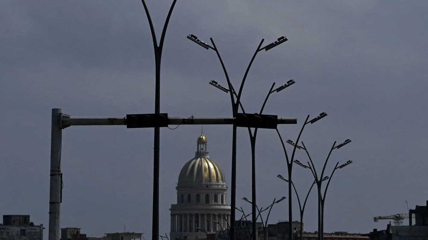 Postes de iluminação apagados em Havana ao entardecer, com o Capitólio ao fundo