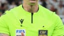 O árbitro Anderson Daronco, de uniforme verde, gesticula durante partida de futebol