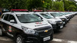 Fila de viaturas brancas e pretas da Polícia Civil de São Paulo estacionadas lado a lado, com giroflex vermelho no teto e o brasão do estado na lataria. Imagem de arquivo.