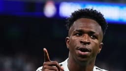 Vinicius Júnior comemora com a camisa do Real Madrid apontando o dedo para cima