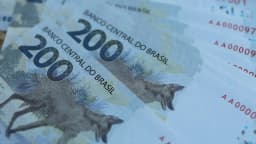 Notas de reais do Banco Central do Brasil espalhadas, com destaque para a nota de R$ 200