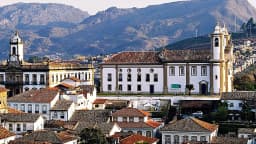 Vista do centro histórico de Ouro Preto, em Minas Gerais, com igrejas coloniais e serra ao fundo
