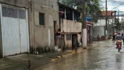 Moradores atravessam rua alagada em São Paulo