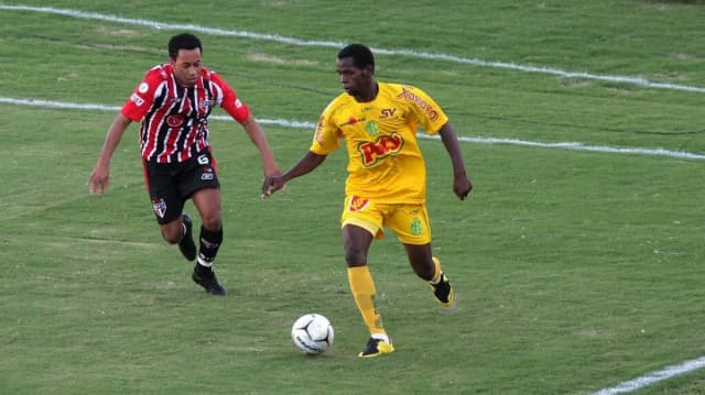 Jogador do Mirassol, de amarelo, disputa bola com adversário em partida de arquivo