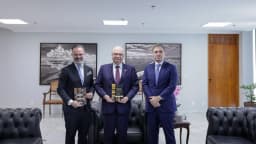André Mendonça posa com dois homens em sala de reunião institucional, foto de arquivo