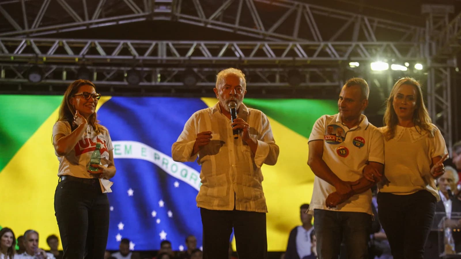 Lula discursa em palanque com bandeira do Brasil ao fundo durante ato de campanha no 2º turno