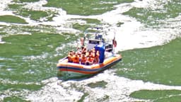 Foto de arquivo de um bote inflável com turistas de colete salva-vidas laranja navegando pelo rio Iguaçu, dentro do Parque Nacional do Iguaçu