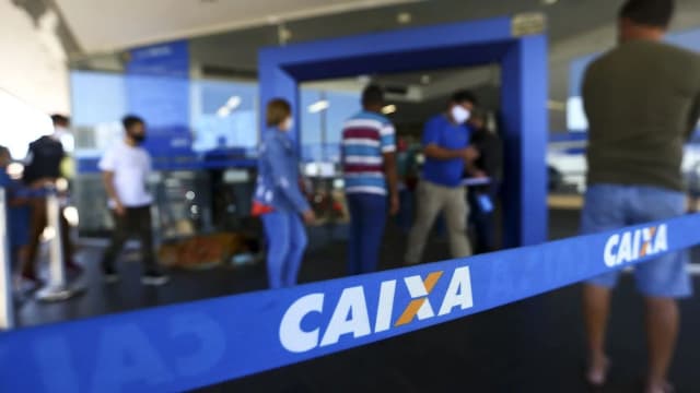 Fila de pessoas em frente a uma agência da Caixa Econômica Federal