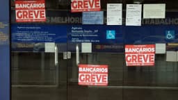 Porta de agência da Caixa Econômica Federal com cartazes de "Bancários em Greve", em Brasília