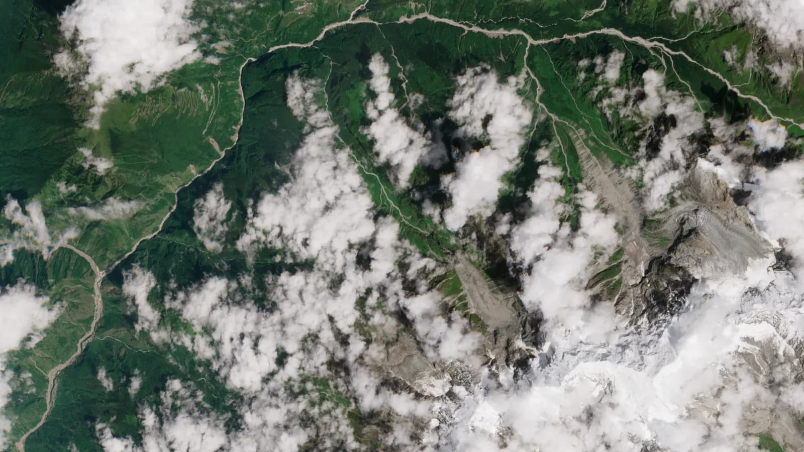 Imagem de satélite da região de Rasuwa, no Nepal, mostrando vales, rios e geleiras cobertos parcialmente por nuvens