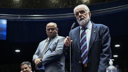 O senador Jaques Wagner discursa em pé, diante do microfone, durante sessão no plenário do Senado; ao lado, outros dois senadores acompanham a fala. Imagem de arquivo.