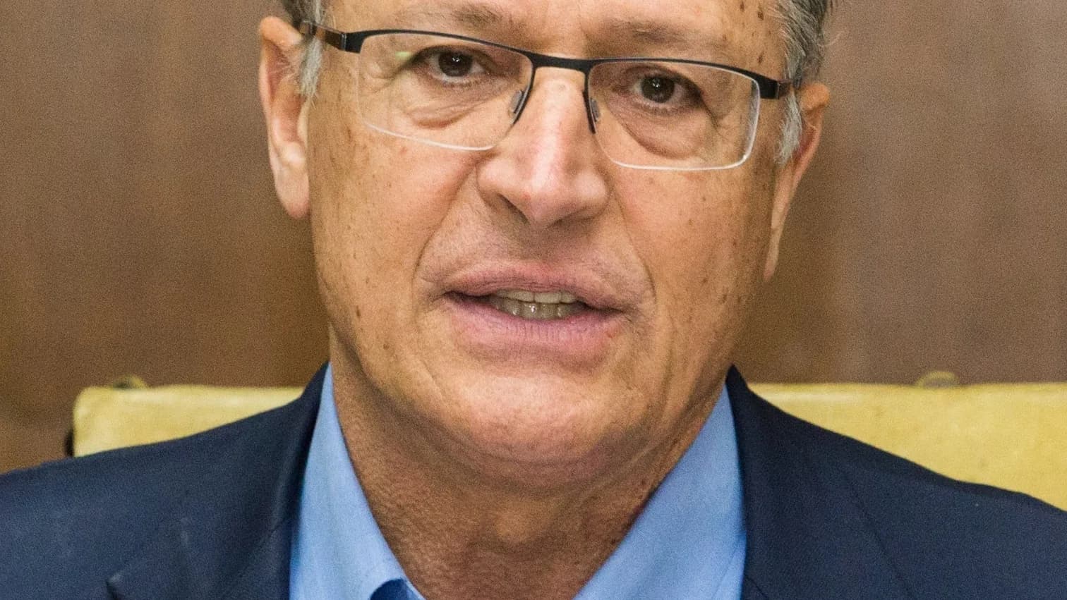 Vice-presidente e ministro Geraldo Alckmin em close, de terno azul, falando em entrevista