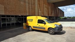 Van amarela dos Correios com identificação Sedex estacionada em frente a prédio público em Brasília