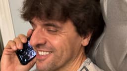 Karl Deisseroth sorri ao telefone no momento em que recebe a notícia do Nobel de Medicina