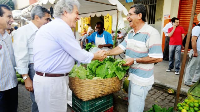 Patrus Ananias cumprimenta comerciante em feira de rua, foto de arquivo de campanha