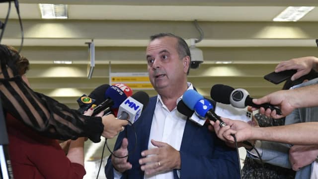 Senador Rogério Marinho fala a jornalistas cercado de microfones no Senado