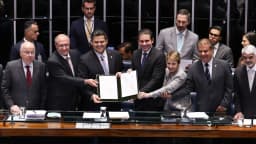 Parlamentares no plenário do Congresso Nacional seguram o texto do acordo Mercosul-União Europeia durante cerimônia de promulgação