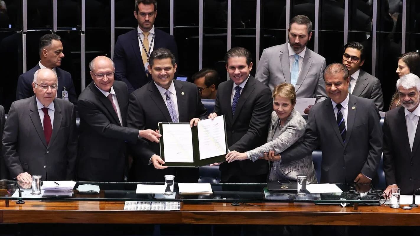 Parlamentares no plenário do Congresso Nacional seguram o texto do acordo Mercosul-União Europeia durante cerimônia de promulgação