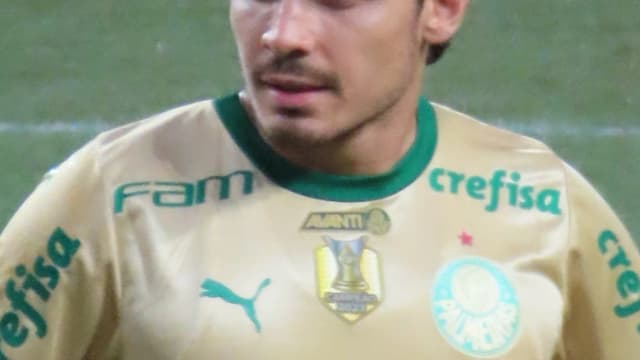 Raphael Veiga, com uniforme dourado do Palmeiras, em campo durante partida