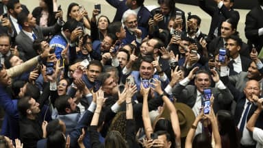 Deputados comemoram e fotografam com celulares durante sessão conjunta do Congresso Nacional no plenário da Câmara