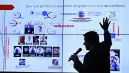 Parlamentar aponta para painel com diagrama do esquema de fraude contra aposentados do INSS na CPMI do INSS