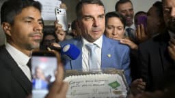 Flávio Bolsonaro concede entrevista a jornalistas em Brasília, cercado por microfones (foto de arquivo, abril de 2026)