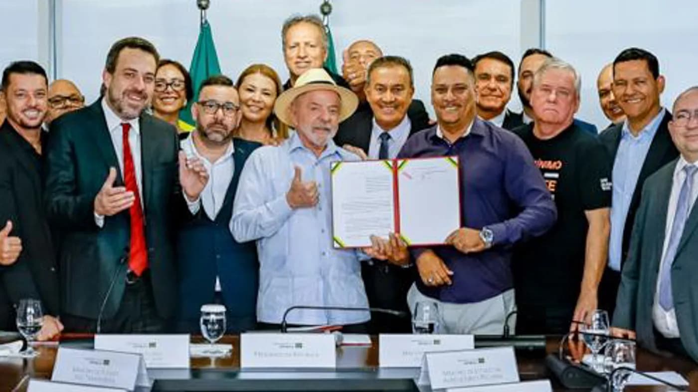Lula sorri e faz sinal de positivo ao lado de auxiliares durante cerimônia no Palácio do Planalto (foto de arquivo)