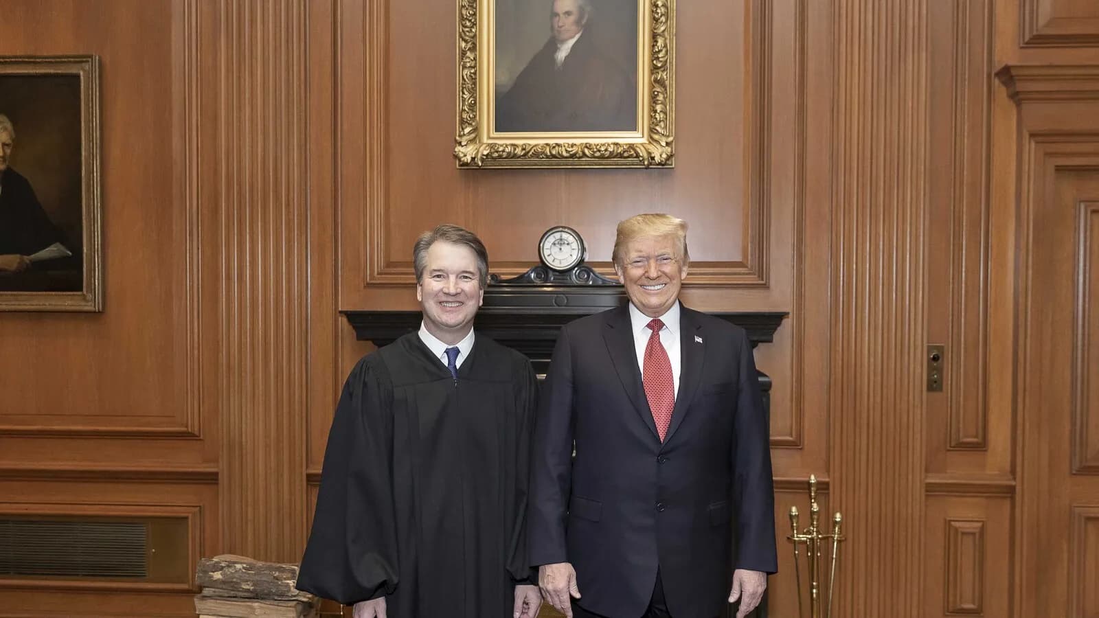 Donald Trump posa sorrindo ao lado do ministro da Suprema Corte Brett Kavanaugh dentro do prédio do tribunal em Washington