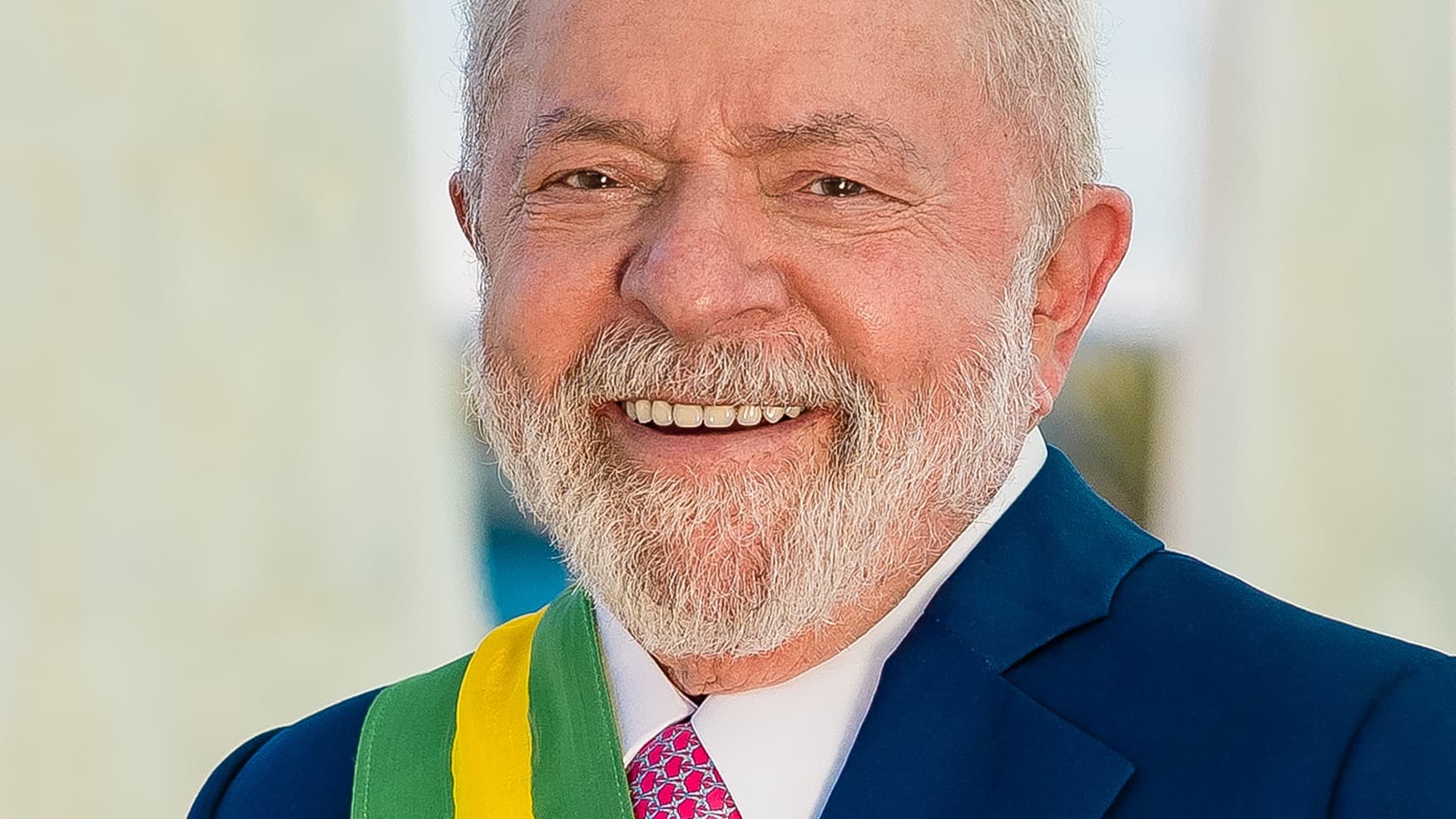 Foto oficial do presidente Luiz Inácio Lula da Silva, sorridente, usando a faixa presidencial