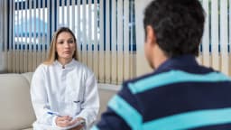 Psicóloga conversa com paciente durante sessão de atendimento psicológico