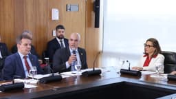 Ministro Alexandre de Moraes fala ao microfone durante reunião, ao lado de outras autoridades
