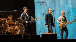 U2 se apresenta no palco durante a Joshua Tree Tour em Bruxelas, com Bono e The Edge tocando