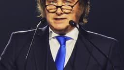 Javier Milei discursa em evento internacional, diante de microfones