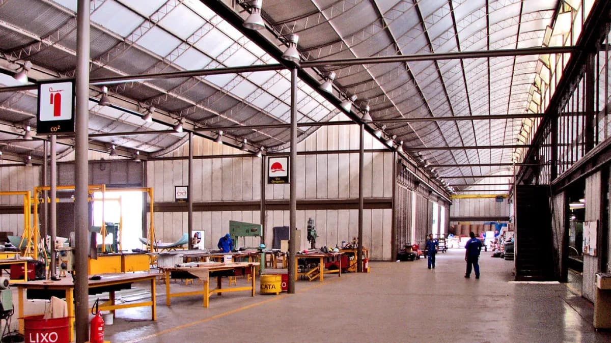 Interior de fábrica com trabalhadores em linha de produção