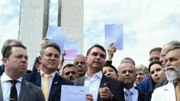 Flávio Bolsonaro ao lado de parlamentares da oposição segura documentos durante coletiva de imprensa