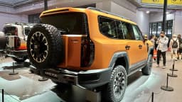 SUV Jetour G700 laranja exposto em salão automotivo