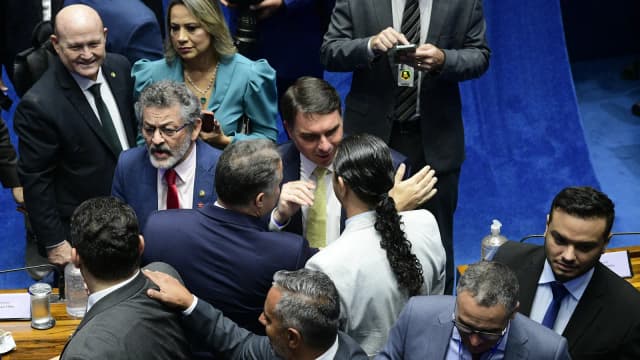 Flávio Bolsonaro em plenário, cercado por outros parlamentares